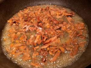 Wine and chanterelles reducing in a non-stick skillet.