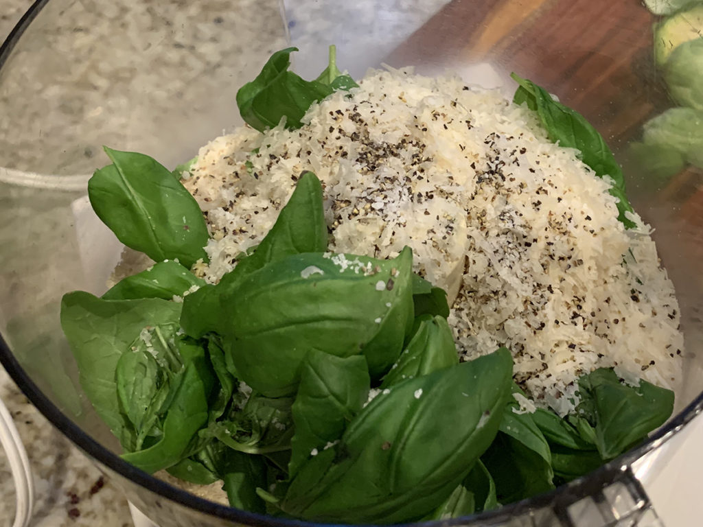Fresh basil, panko bread crumbs, parmesan cheese, salt & pepper ready to be blended in a food processor. 
