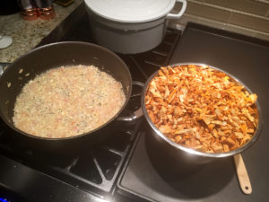 skillet with sautéed shallots, bowl with chopped chanterelles on a stove top.