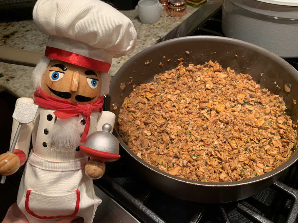 chanterelle duxelles in a skillet with a nutcracker that looks like a chef