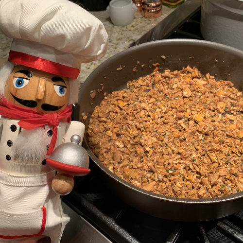 chanterelle duxelles in a skillet with a nutcracker that looks like a chef