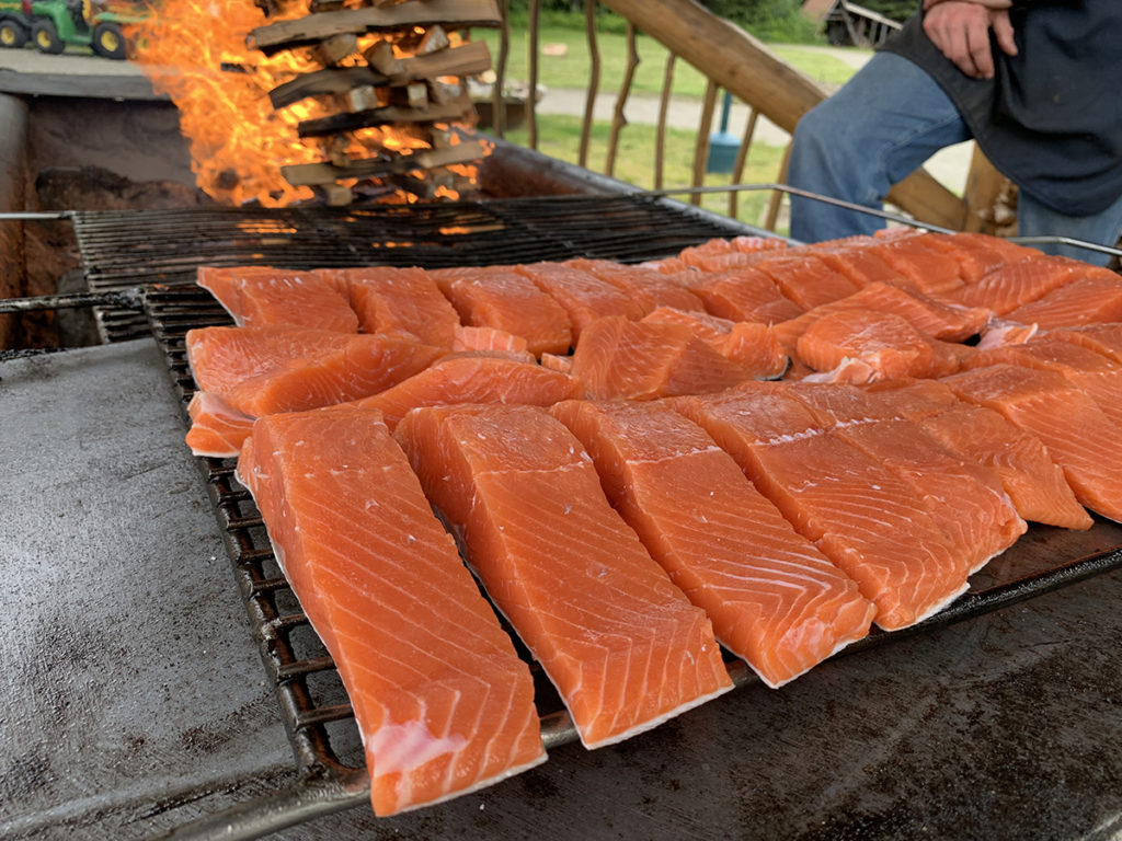 Several pieces of wild salmon on an outdoor grill.
