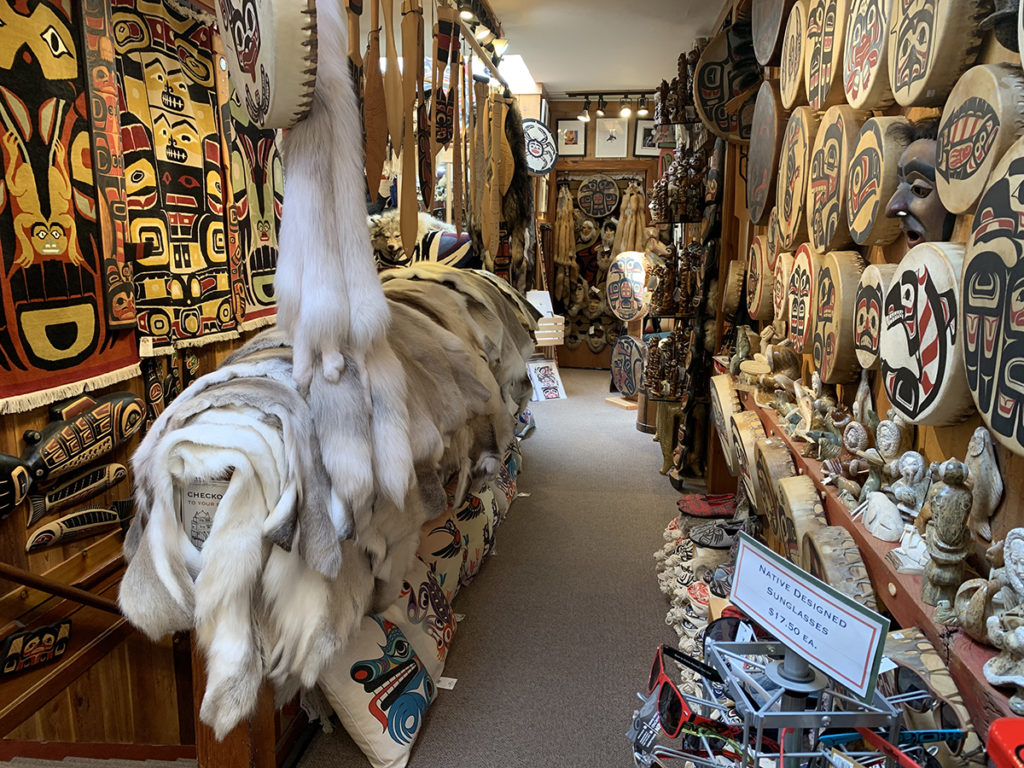isle in native souvenir shop filled with furs, drums, printed pillows, carvings, rugs.