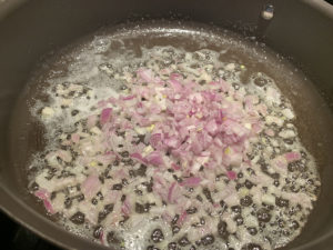 chopped shallots simmering in a nonstick pan