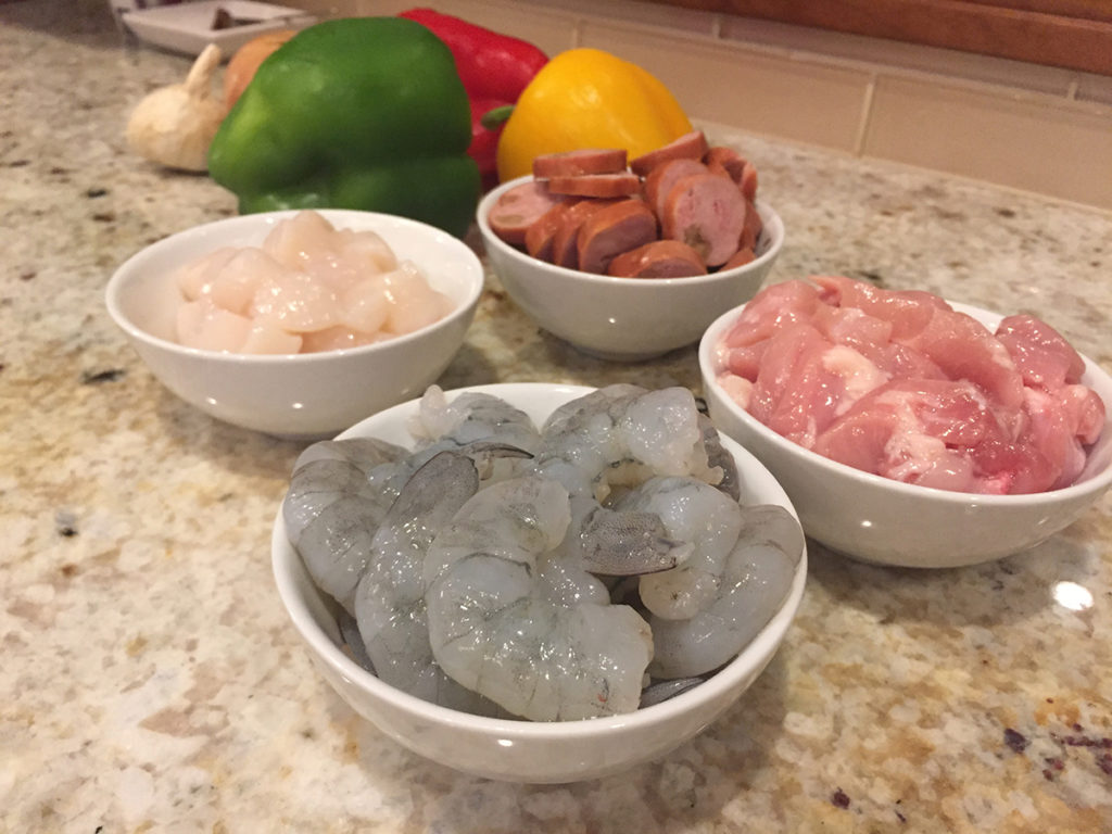 Raw shrimp, scallops, chicken thighs and andouille sau