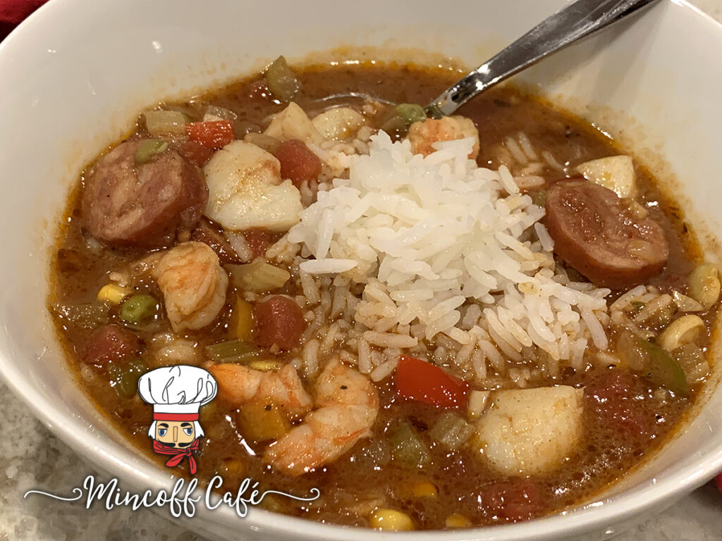 colorful bowl of seafood & chicken gumbo in a white bowl