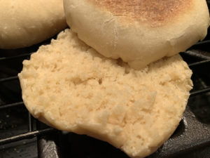 close up image of split open homemade English muffin showing the texture inside and out.