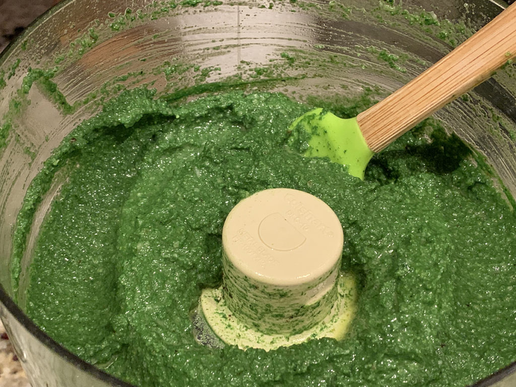 Bright green stinging nettle pesto in a food processor. 
