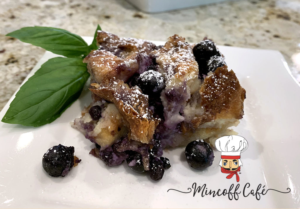 Blueberry & Cream Cheese Croissant Puff on a white plate with fresh basil garnish.