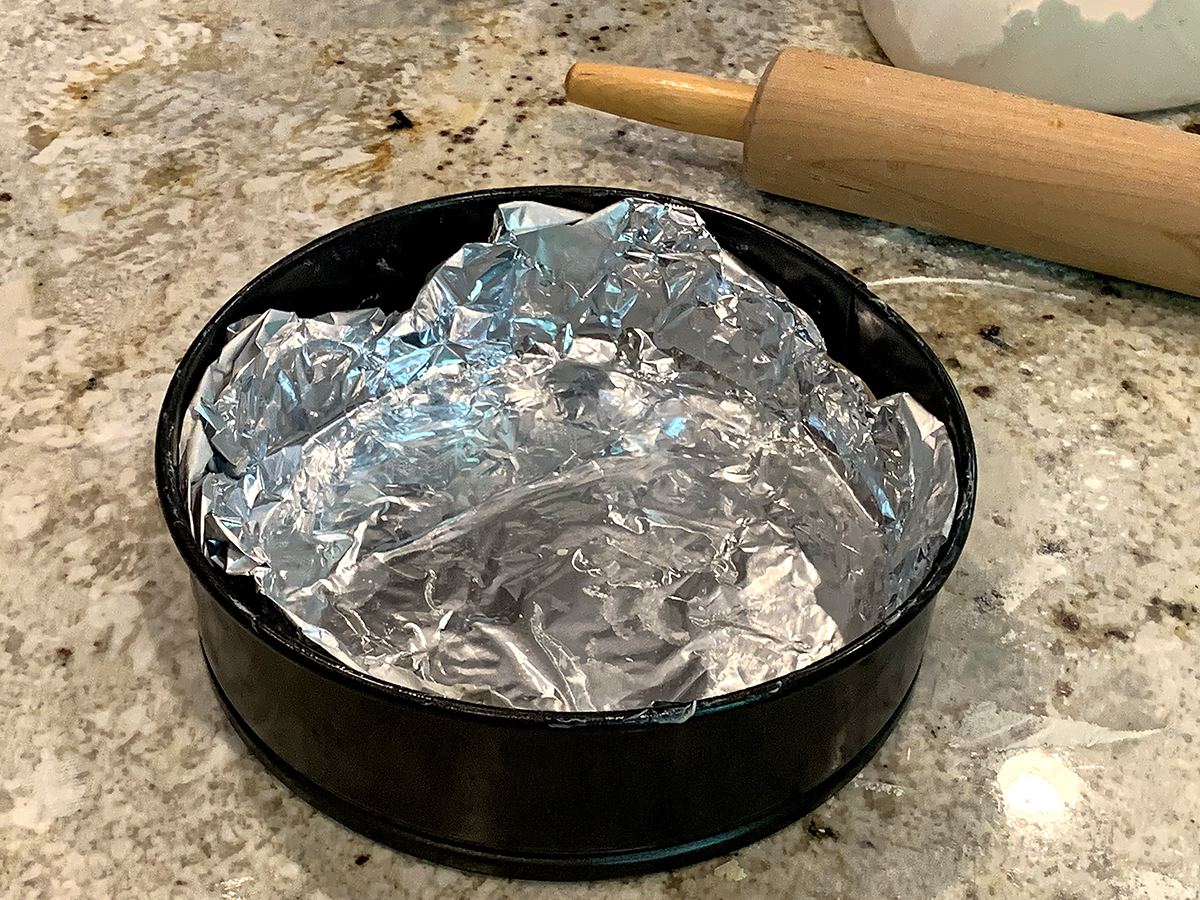 Buttered sheet of foil pressed into a spring form pan.