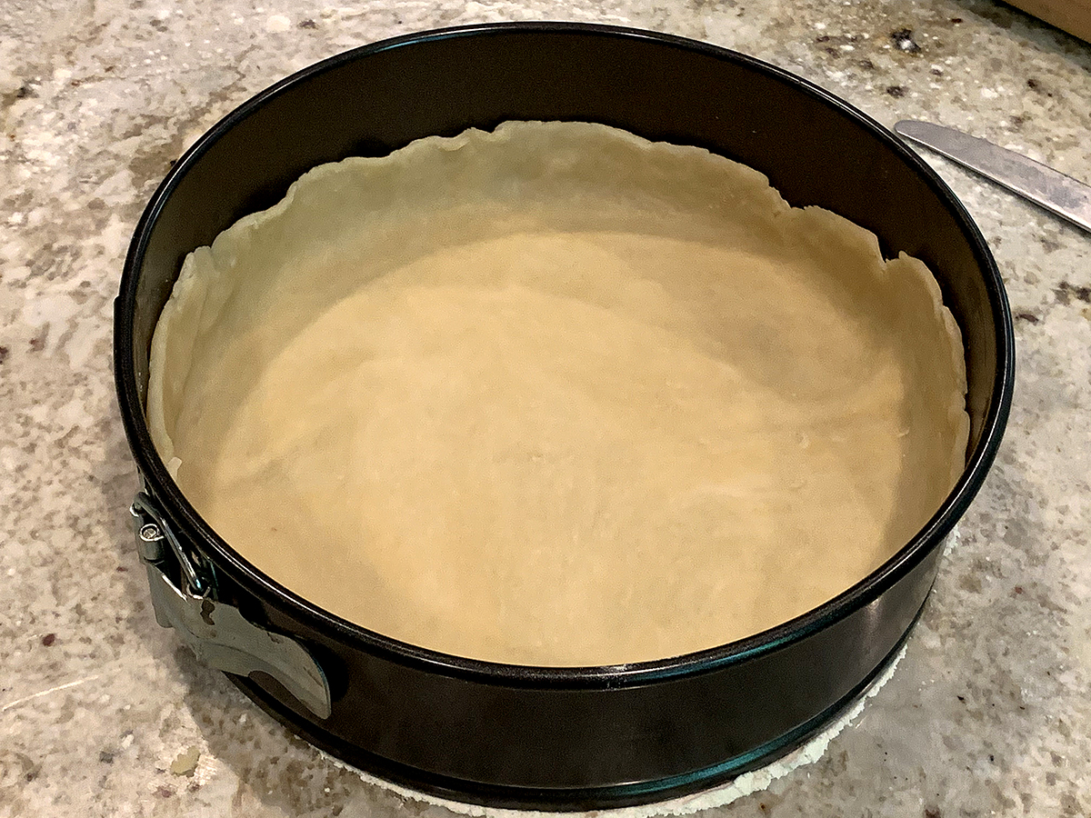 Pastry dough in springform pan with edges pressed up the sides about 1.5 inches. 