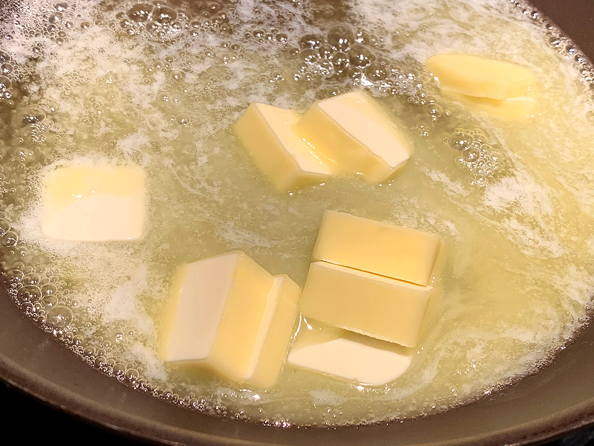 Cubes of butter melting in a small skillet. 