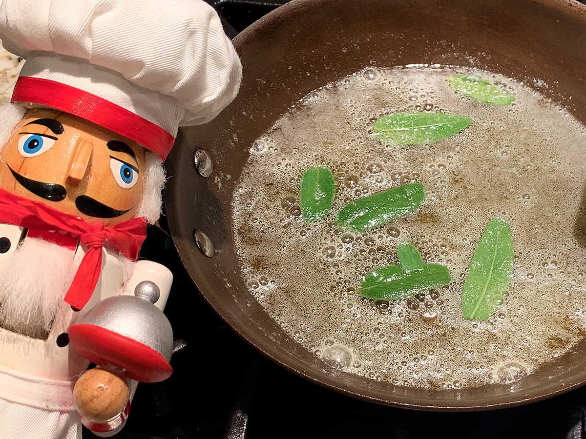 Fresh sage leaves in skillet with melted butter to make a sage brown butter. 
