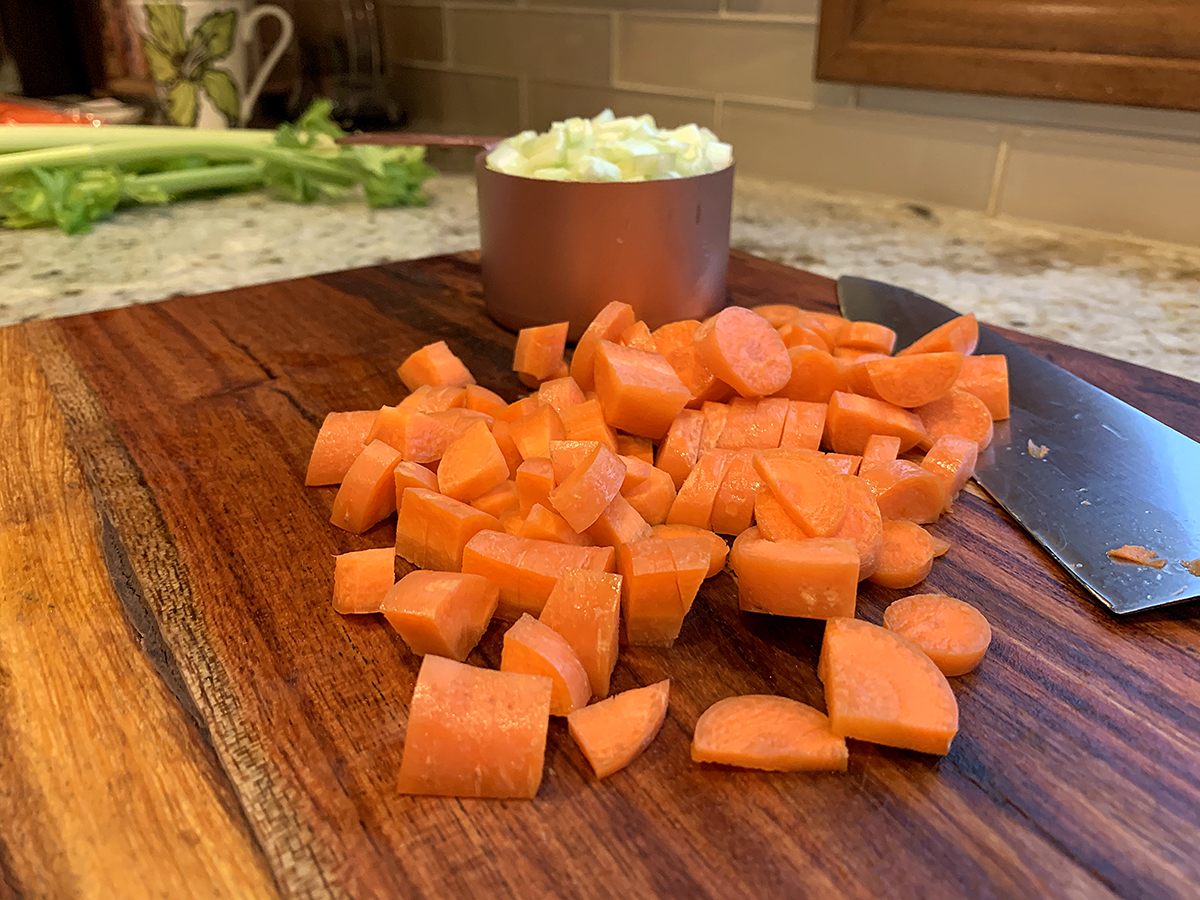 Chopped Carrots on a wood cutting board.