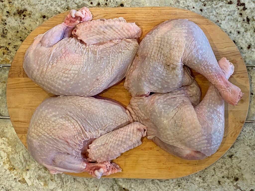 Turkey laid out into portions of white meat and dark meat.