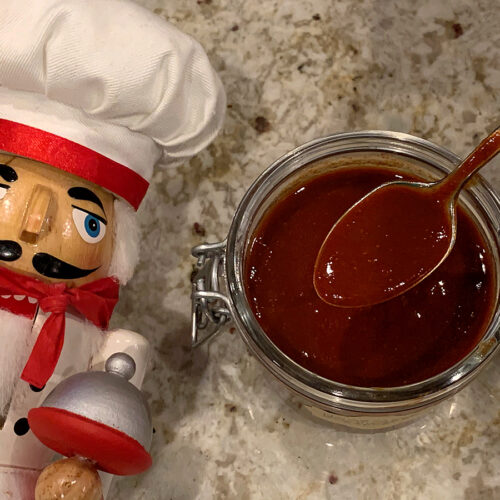 Red enchilada sauce with spoon and a nutcracker who looks like a chef.