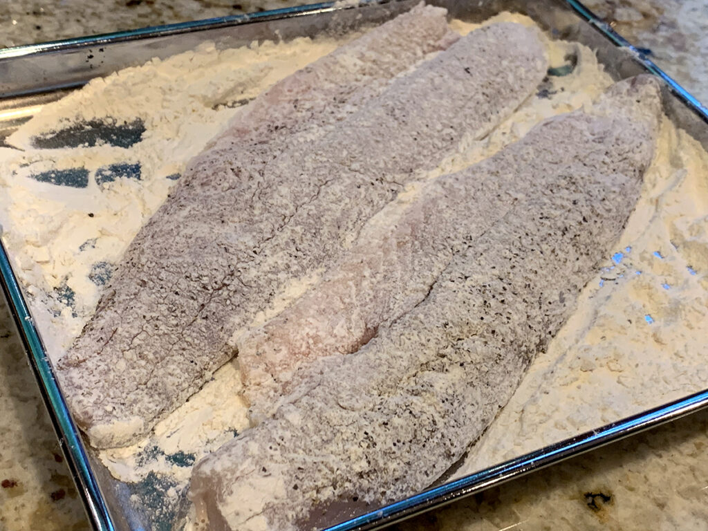 Two walleye fillets lightly dredged in flour.