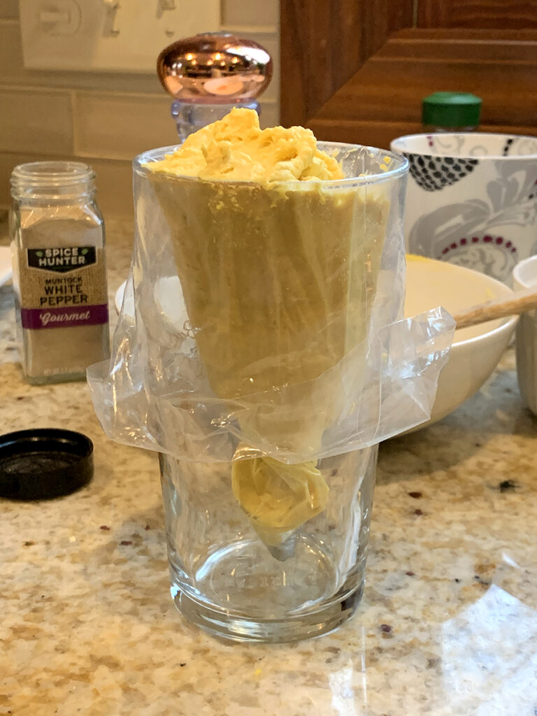 Pint glass filled with a clear piping back and then filled with deviled egg mixture.